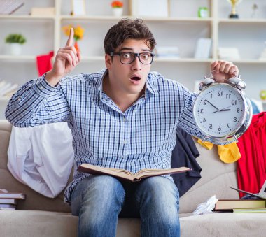 Genç adam dağınık bir odada çalışıyor.