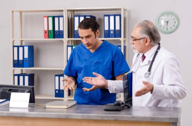 Hastanedeki resepsiyonda iki doktor konuşuyor.