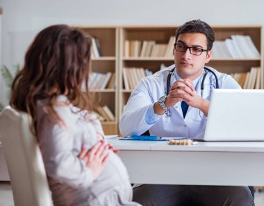 Hamile kadın muayene için doktoru ziyaret ediyor.