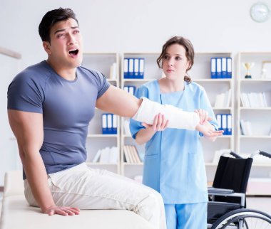 Hastanede yaralanma kontrolü sırasında doktor ve hasta.