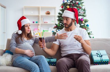 Genç aile Noel 'i kutlayan bir bebek bekliyor.