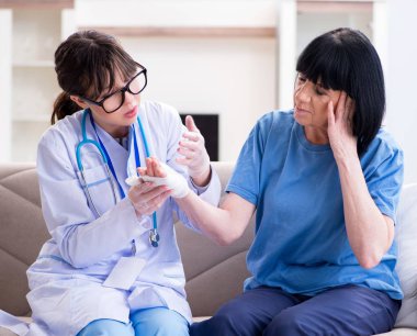 Doktor olaydan sonra yaşlı kadını muayene ediyor.