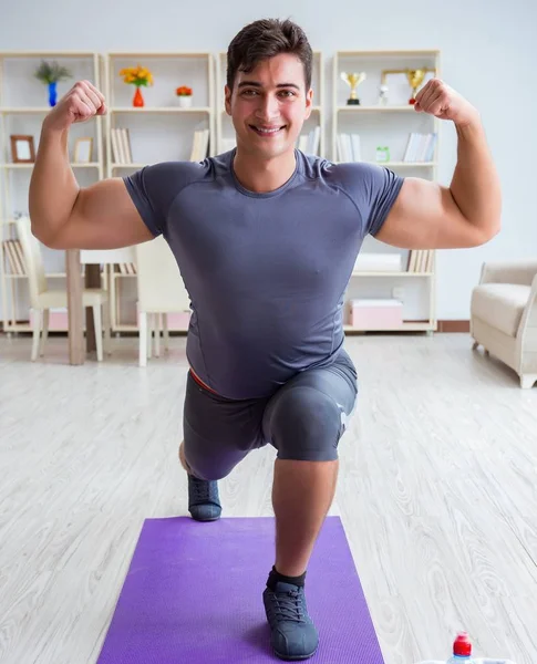 Giovane uomo che esercita a casa in sport e stile di vita sano con — Foto Stock