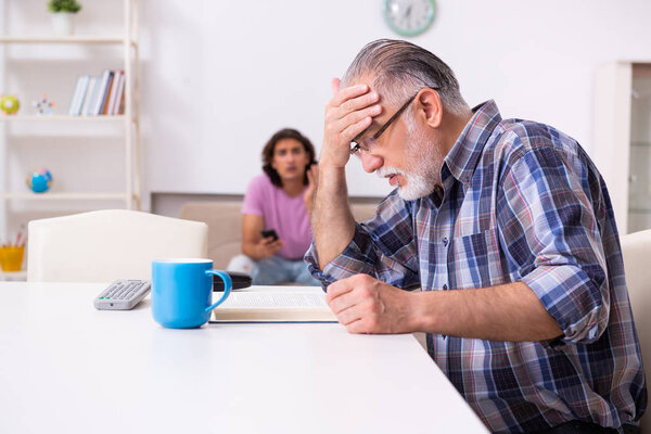 Young student and his old grandpa at home