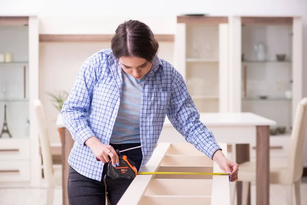 Jovem bela mulher montando móveis em casa — Fotografia de Stock