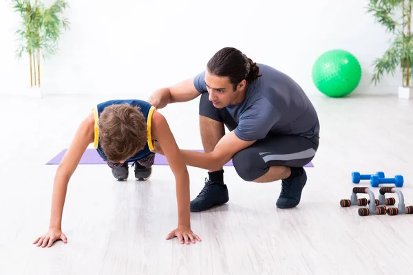 Jovem pai e seu filho fazendo exercícios — Fotografia de Stock