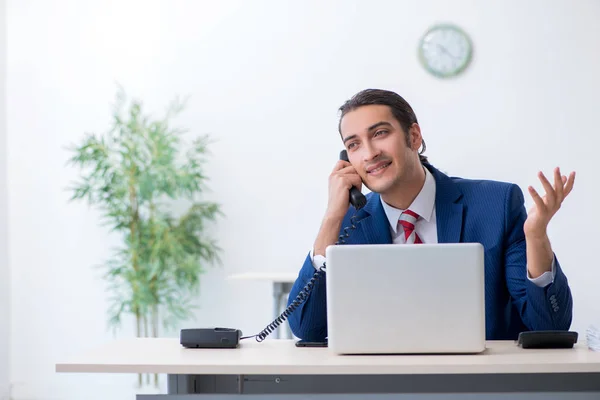 Junge männliche Geschäftsmann sitzt im Büro — Stockfoto