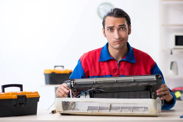 Ung reparatör som reparerar luftkonditioneringen på garanticentret — Stockfoto