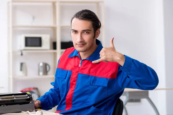 Young repairman repairing air-conditioner at warranty center — Stock Photo, Image