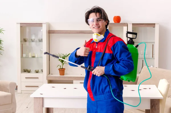 Jovem empreiteiro fazendo controle de pragas em casa — Fotografia de Stock