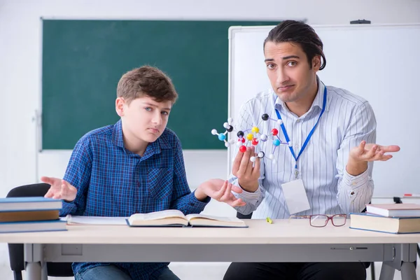 Jonge mannelijke leraar uitleggen moleculair model — Stockfoto