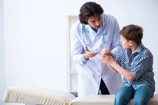 Hand skadad pojke besöker ung manlig läkare — Stockfoto