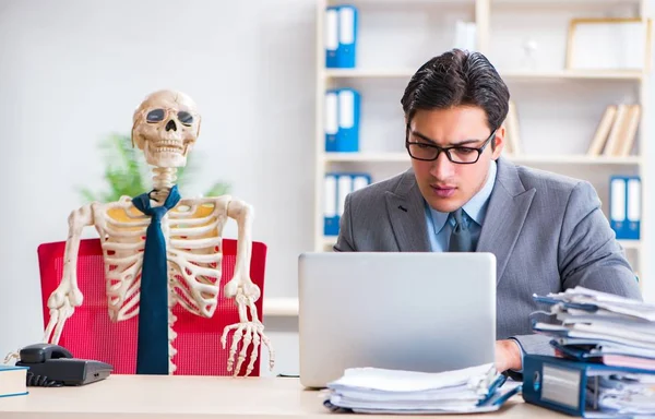 Geschäftsmann arbeitet mit Skelett im Büro — Stockfoto