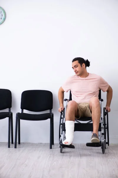 Young injured man waiting for his turn in hospital hall — Stock Photo, Image