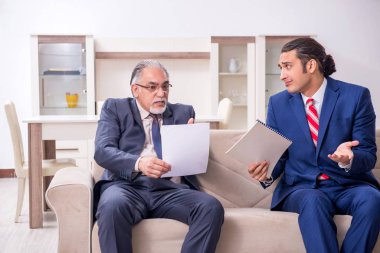 İki işadamı ofiste iş konuşuyor.