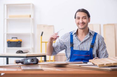 Genç erkek marangoz içeride çalışıyor.