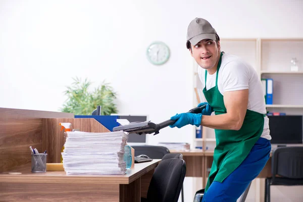 Jovem empreiteiro bonito limpando o escritório — Fotografia de Stock