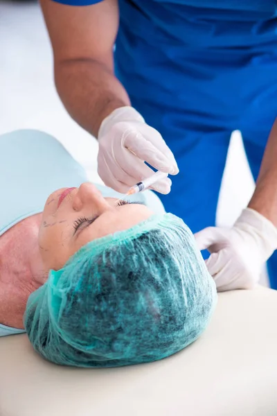 Anciana visitando a médico masculino para cirugía plástica — Foto de Stock