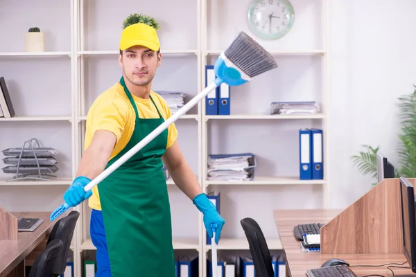 Junge männliche Auftragnehmer putzen das Büro — Stockfoto