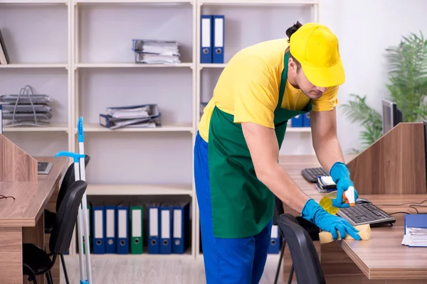 Junge männliche Auftragnehmer putzen das Büro — Stockfoto