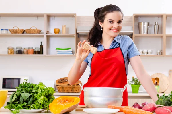 Jonge vrouw met groenten in de keuken — Stockfoto