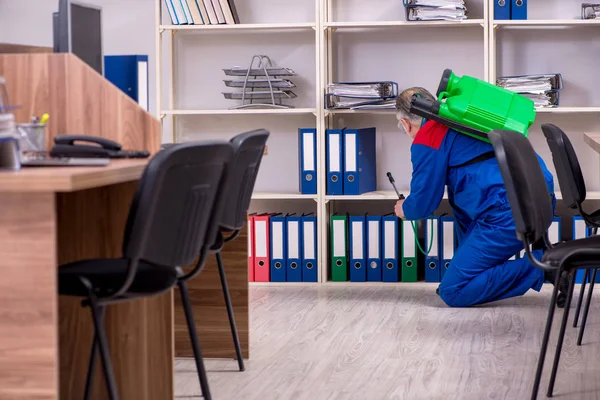 Oude professionele aannemer doet ongediertebestrijding in het kantoor — Stockfoto