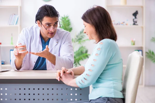 Orta yaşlı bir kadın, erkek doktor stomatoloğu ziyaret ediyor. — Stok fotoğraf