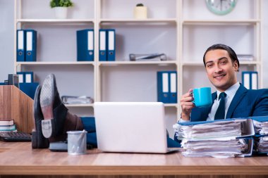 Genç yakışıklı işadamı ofiste çalışıyor.