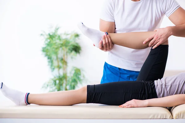 Mujer joven que visita al médico fisioterapeuta masculino — Foto de Stock