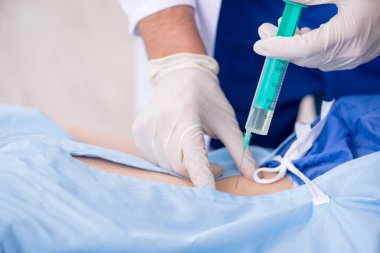 Kadın hasta klinikte iğne oluyor.