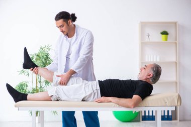 Yaşlı adam genç doktoru ziyaret ediyor.