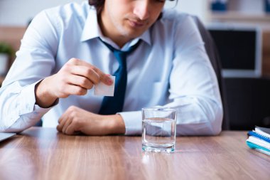 Hasta erkek çalışan ofiste acı çekiyor.