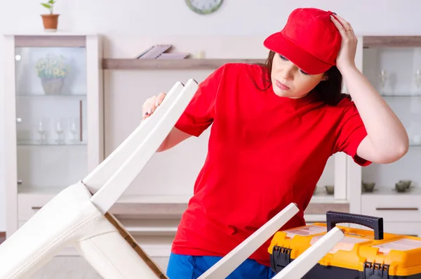 Jonge vrouw repareert stoel thuis — Stockfoto