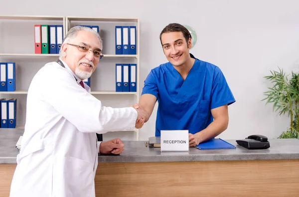 Dwóch lekarzy rozmawiających w recepcji w szpitalu. — Zdjęcie stockowe