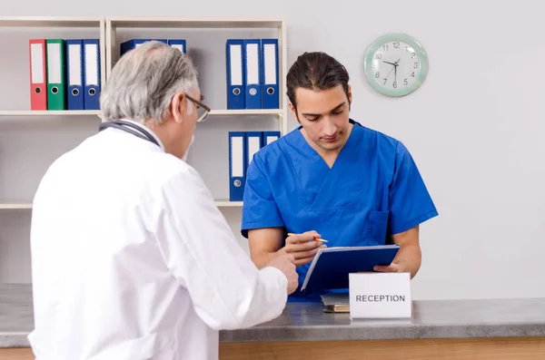 Dois médicos conversando na recepção no hospital — Fotografia de Stock