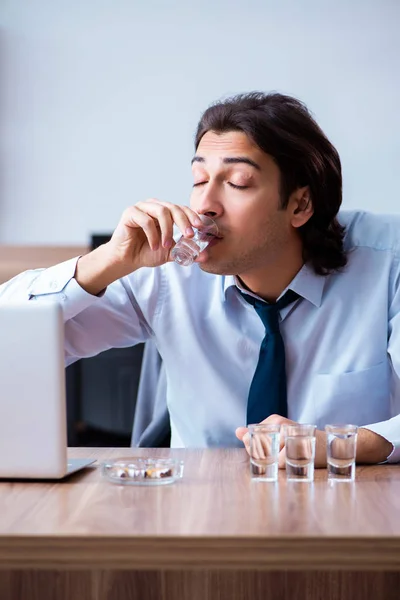 Hombre empleado beber vodka y fumar cigarrillos en el lugar de trabajo — Foto de Stock