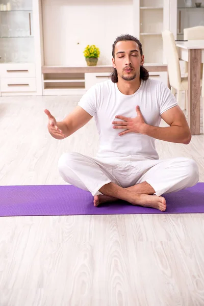 Jovem fazendo exercícios físicos em casa — Fotografia de Stock