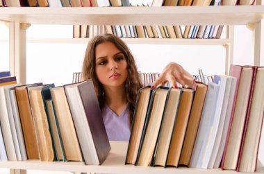 Genç kız öğrenci kütüphanede sınava hazırlanıyor.