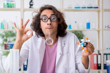 Laboratuvarda çalışan komik erkek kimyager.