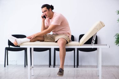 Genç yaralı adam hastane koridorunda sırasını bekliyor.