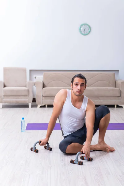 Jovem treinando e exercitando em casa — Fotografia de Stock