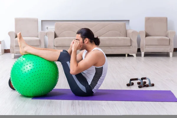 Jovem treinando e exercitando em casa — Fotografia de Stock