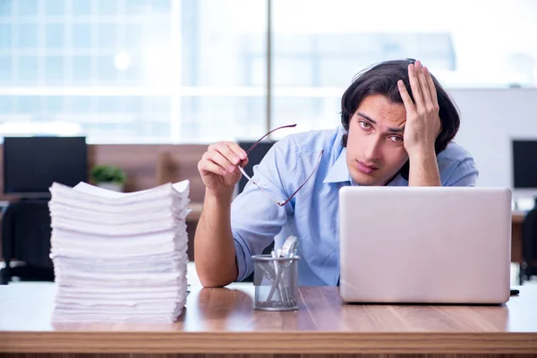 Jovem funcionário infeliz com excesso de trabalho — Fotografia de Stock