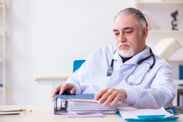 Klinikte çalışan yaşlı erkek doktor. — Stok fotoğraf