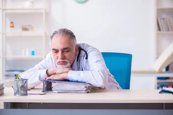 Klinikte çalışan yaşlı erkek doktor. — Stok fotoğraf