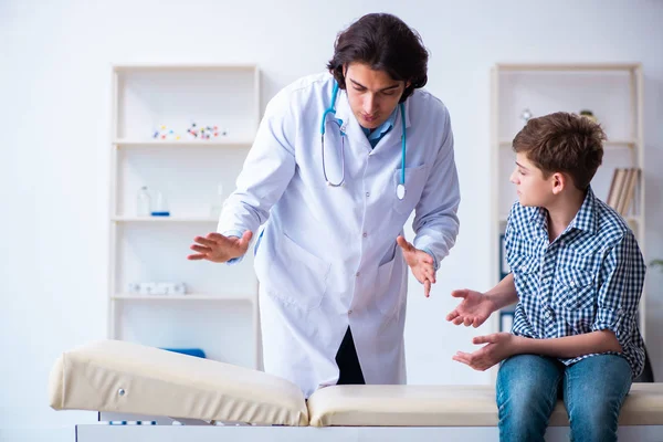 Jovem médico examinando estudante para check-up regular — Fotografia de Stock
