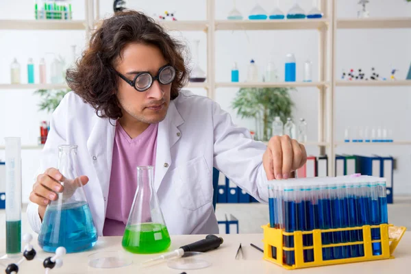 Grappige mannelijke chemicus die in het lab werkt — Stockfoto