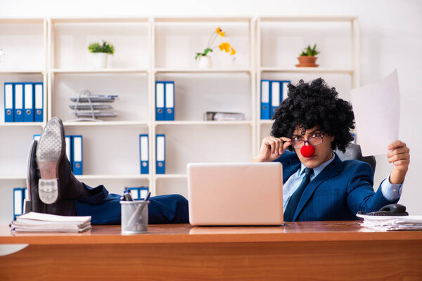 Young clown businessman working in the office