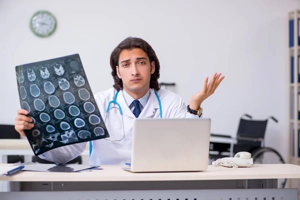 Ung manlig röntgenläkare som arbetar på kliniken — Stockfoto