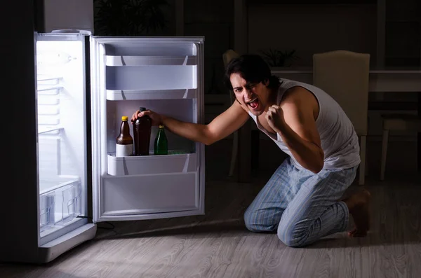 Man bryter diet på natten nära kylskåp — Stockfoto